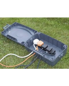 weatherproof box with extension lead laying open on grass
